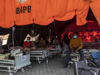 Patients sit in an emergency tent for COVID-19 treatment which was set up at Undata Hospital, Palu, Central Sulawesi Province, Indonesia on...