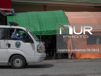 An ambulance driver raises his thumb after transporting patients to an emergency tent for COVID-19 treatment which was set up at Undata Hosp...