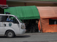 An ambulance driver raises his thumb after transporting patients to an emergency tent for COVID-19 treatment which was set up at Undata Hosp...