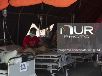 Patients sit in an emergency tent for COVID-19 treatment which was set up at Undata Hospital, Palu, Central Sulawesi Province, Indonesia on...