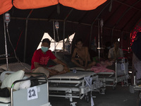 Patients sit in an emergency tent for COVID-19 treatment which was set up at Undata Hospital, Palu, Central Sulawesi Province, Indonesia on...