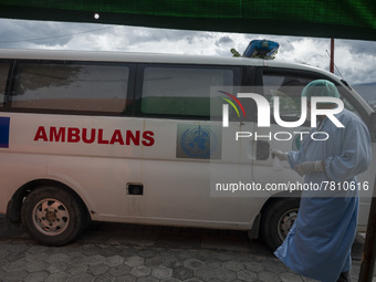 A driver sprays disinfectant liquid on an ambulance after transporting patients to an emergency tent for COVID-19 treatment which was set up...