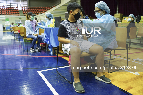 People receive doses of the Pfizer COVID-19 vaccine at a vaccination center inside a stadium in Bangkok, Thailand, 24 February 2022. 