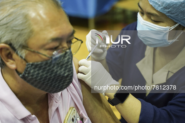 People receive doses of the Pfizer COVID-19 vaccine at a vaccination center inside a stadium in Bangkok, Thailand, 24 February 2022. 