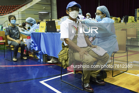 People receive doses of the Pfizer COVID-19 vaccine at a vaccination center inside a stadium in Bangkok, Thailand, 24 February 2022. 