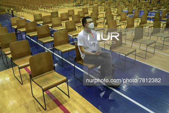 People sit and wait up to receive the COVID-19 vaccine at a vaccination center inside a stadium in Bangkok, Thailand, 24 February 2022. 