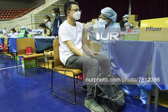 People receive doses of the Pfizer COVID-19 vaccine at a vaccination center inside a stadium in Bangkok, Thailand, 24 February 2022. 