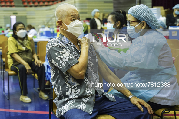 People receive doses of the Pfizer COVID-19 vaccine at a vaccination center inside a stadium in Bangkok, Thailand, 24 February 2022. 