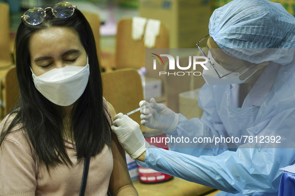 People receive doses of the Pfizer COVID-19 vaccine at a vaccination center inside a stadium in Bangkok, Thailand, 24 February 2022. 