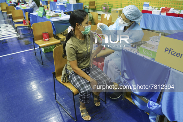 People receive doses of the Pfizer COVID-19 vaccine at a vaccination center inside a stadium in Bangkok, Thailand, 24 February 2022. 