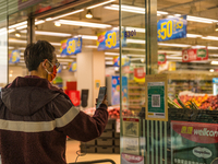 A man scans the Leave Home Safe QR code outside a supermarket, in Hong Kong, China, on February 24, 2022. As of today, it is compulsory to b...