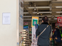 A woman scans the Leave Home Safe QR code before entering a supermarket in the Kowloon Bay area, in Hong Kong, China, on February 24, 2022....