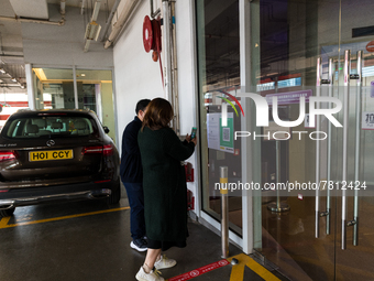 Office workers scan the Leave Home Safe QR code before entering a the Megabox department store, in Hong Kong, China, on February 24, 2022  A...