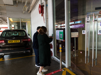 Office workers scan the Leave Home Safe QR code before entering a the Megabox department store, in Hong Kong, China, on February 24, 2022  A...