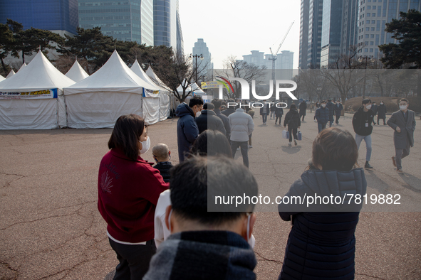 People wait for COVID-19 test at a temporary testing site in Yeouido finance and investment banking district on February 25, 2022 in Seoul,...