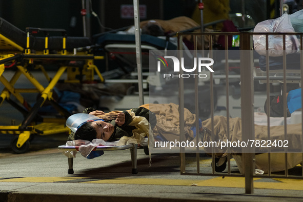 A COVID patient is placed on a stretcher left on the floor outside the Caritas Medical Centre in Sham Shui Po, in Hong Kong, China, on Febru...