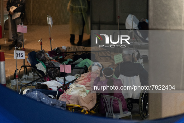 COVID patients sit outside the Accident and Emergency Ward at the Caritas Medical Centre, in Hong Kong, China, on February 25, 2022. 