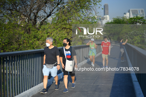 People wearing a face mask as a preventive measure against the spread of COVID-19 walk around sky walk at the Benchakitti Forest Park on Feb...