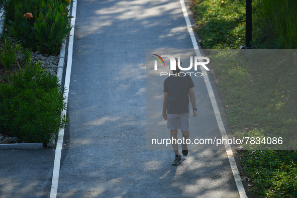 People wearing a face mask as a preventive measure against the spread of COVID-19 walk around the Benchakitti Forest Park on February 27, 20...