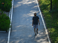 People wearing a face mask as a preventive measure against the spread of COVID-19 walk around the Benchakitti Forest Park on February 27, 20...