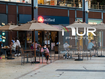 People eat outdoors at Stanley Plaza after 6 pm in Hong Kong, China, on February 27, 2022. (