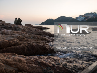 The rising tide swirls around a rock in Stanley as the sun sets in Hong Kong, China, on February 27, 2022. (