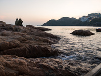 The rising tide swirls around a rock in Stanley as the sun sets in Hong Kong, China, on February 27, 2022. (