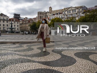 A woman wearing a protective mask is seen walking around Praça de Rossio, Lisbon. February 20, 2022. The Portuguese General Health Direction...