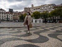 A woman wearing a protective mask is seen walking around Praça de Rossio, Lisbon. February 20, 2022. The Portuguese General Health Direction...