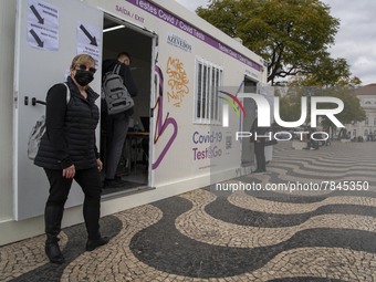 A woman wearing a protective mask is seen waiting for a turn to take a COVID-19 test at one of the stands set up for this purpose in the sur...