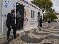 A woman wearing a protective mask is seen waiting for a turn to take a COVID-19 test at one of the stands set up for this purpose in the sur...