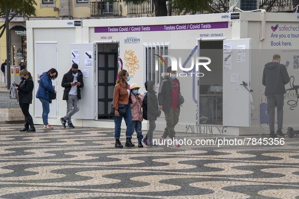 People wearing protective masks are seen waiting for a turn to take a COVID-19 test at one of the stands set up for this purpose in the surr...