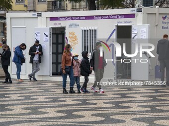 People wearing protective masks are seen waiting for a turn to take a COVID-19 test at one of the stands set up for this purpose in the surr...