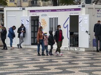 People wearing protective masks are seen waiting for a turn to take a COVID-19 test at one of the stands set up for this purpose in the surr...