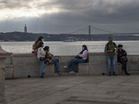 People wearing protective masks are seen resting on the banks of the Tejo river, in the Cais das Colunas area, Lisbon. February 20, 2022. Th...