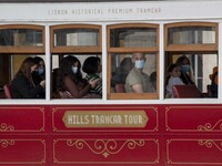 People wearing protective masks are seen riding in a tram around Praça de Comercio, Lisbon. February 20, 2022. The Portuguese General Health...