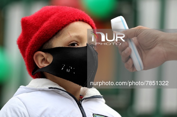 An employee checks the temperature of a student at the entrance of Baramulla public school in Baramulla Jammu and Kashmir India on 02 March...