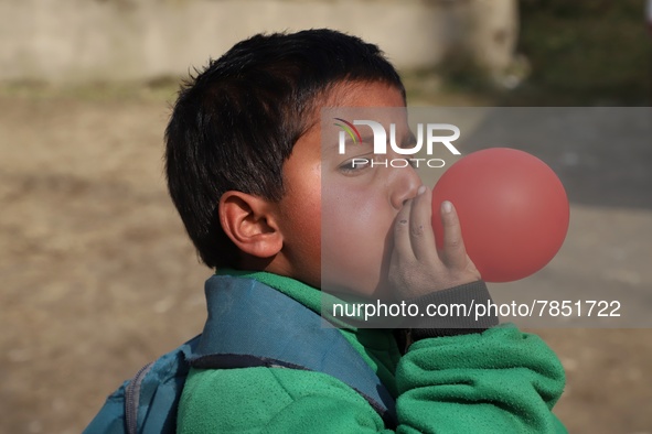 A student inflate a balloon he took after school opening ceremony at a government school in Baramulla Jammu and Kashmir India on 02 March 20...