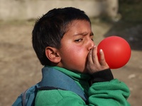 A student inflate a balloon he took after school opening ceremony at a government school in Baramulla Jammu and Kashmir India on 02 March 20...