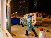 Paramedics get read to take their ambulance back on the road after delivering patients to United Christian Hospital in Kwun Tong, in Hong Ko...