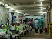 Nurses walk in front of COVID patients left outside the Accident & Emergency ward of United Christian Hospital in Kwun Tong, in Hong Kong, C...