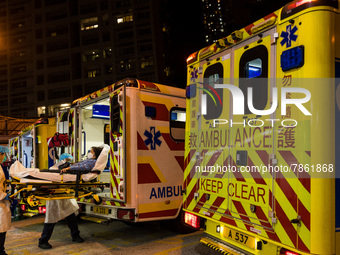 Paramedics in PPE unload a patient from an ambulance at United Christian Hospital in Kwun Tong, in Hong Kong, China, on March 04, 2022. (