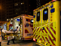 Paramedics in PPE unload a patient from an ambulance at United Christian Hospital in Kwun Tong, in Hong Kong, China, on March 04, 2022. (