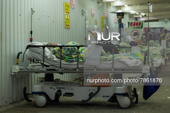 A patient lies in a bed outside the Accident & Emergency ward of the United Christian Hospital, in Kwun Tong, in Hong Kong, China, on March...