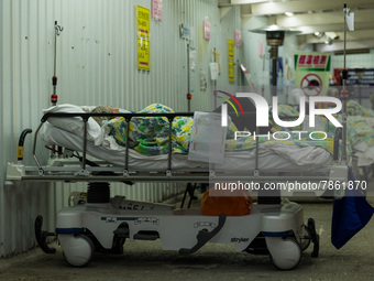 A patient lies in a bed outside the Accident & Emergency ward of the United Christian Hospital, in Kwun Tong, in Hong Kong, China, on March...