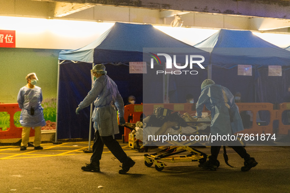 Paramedics in PPE perform CPR on a patient in cardiac arrest at the Accident & Emergency ward of Queen Elisabeth Hospital, transporting him...