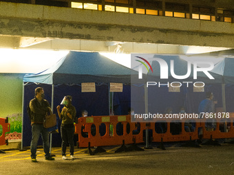 Patients brought in by ambulances await under tents in the courtyard of Queen Elisabeth hospital, in Hong Kong, China, on March 04, 2022. (