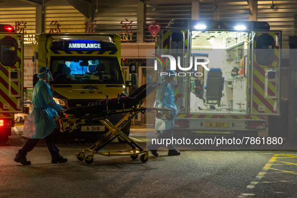 Paramedics in PPE bring back a stretcher to their ambulance, in Hong Kong, China, on March 04, 2022. 