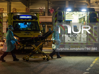 Paramedics in PPE bring back a stretcher to their ambulance, in Hong Kong, China, on March 04, 2022. (