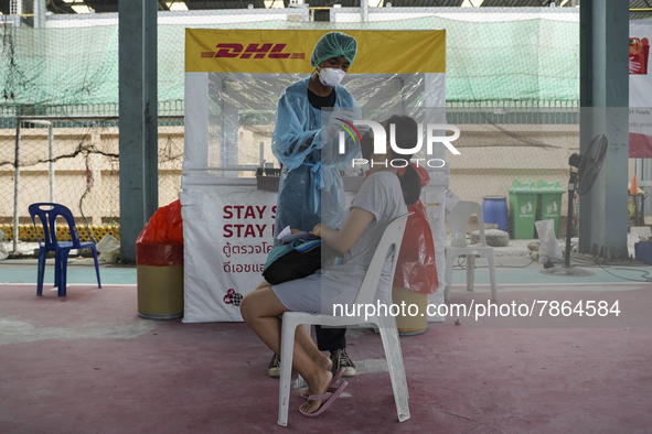 A health worker from Khlongtoey Deejung organisation takes a swab sample for a rapid antigen test, amid the coronavirus Omicron (COVID-19) p...